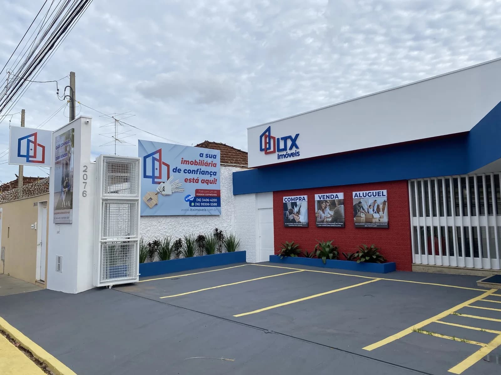 Fachada real da LTX Imóveis, com entrada e estacionamento
